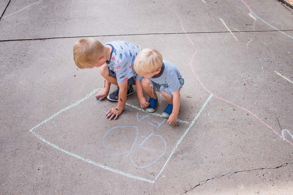 Boys make chalk drawings in an East Grand Rapids driveway during a family documentary session