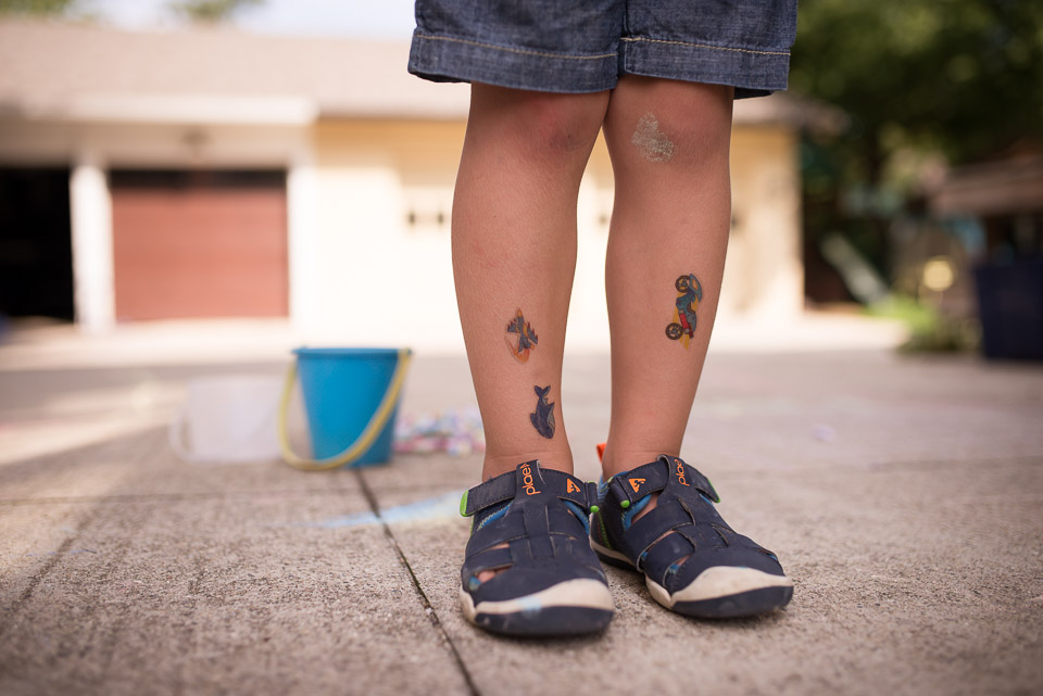 Close up documentary family photo of fake tattoos on a young boys legs