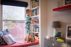 Boy selects books to read for Grand Rapids family documentary day in the life session