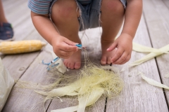 Child plays with a snake during family documentary session