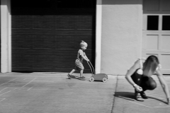 Boy on zooms past mother in this black and white East Grand Rapids documentary photo