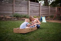 Boy laughs while tickled during a documentary style family session near East Grand Rapids