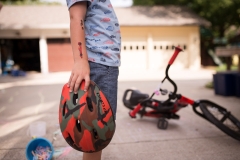 Close up of boys play tattoos and bike helmet during documentary style family session