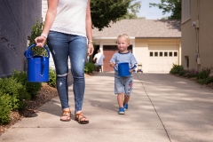 Mother and son carry watering cans during an East Grand Rapids day in the life session