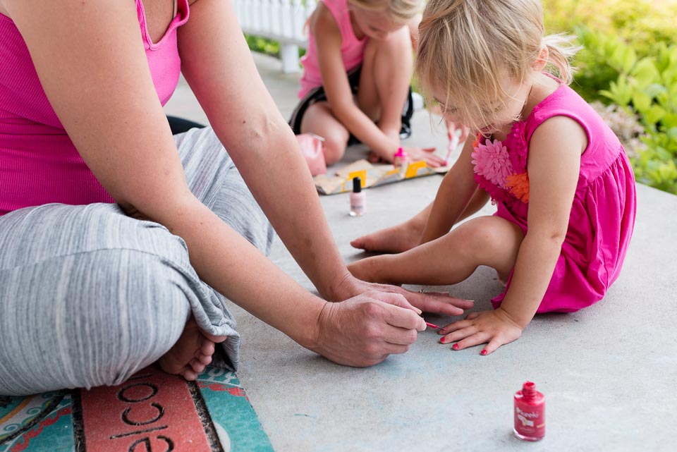 Mother paints a child's toenails during a day in the life session near Grand Rapids