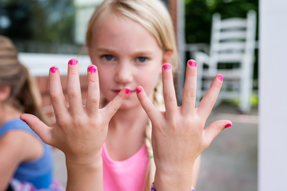 Child displays her painted nails during a family documentary day in the life photography session