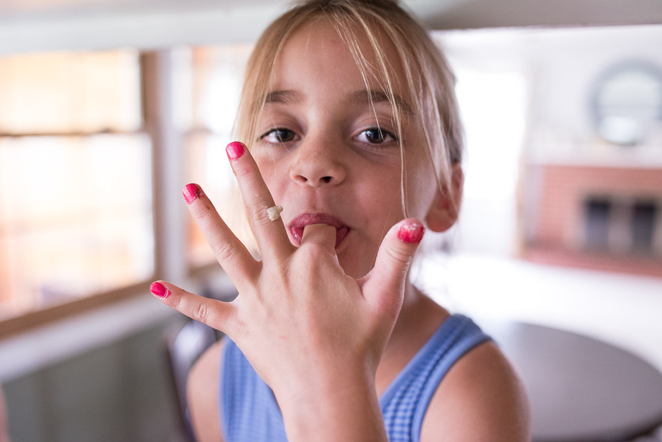 Grand Rapids child licks cookie dough from fingers during day in the life documentary session