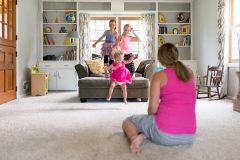 Grand Rapids mother watches her daughters play during documentary family session photography