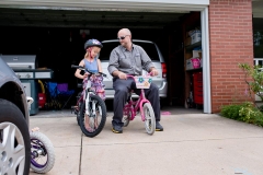 Father and daughter sit on bikes in a Grand Rapids day in the life session