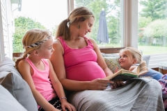 Grand Rapids family documentary image of pregnant mother reading to her children.