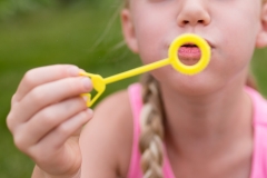 Close up of Grand Rapids child photography image of blowing bubbles