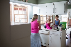 Pregnant mother and three girls bake cookies during a documentary family photography session