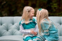 Two young girls laugh together in a West Michigan candid family portrait