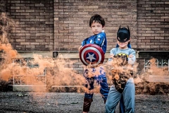 Orange smoke floats around boys in superhero costumes in this creative Grand Rapids child portrait
