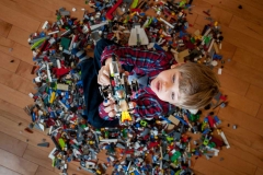 Lego bricks surround a boy and his creation in this creative child portrait