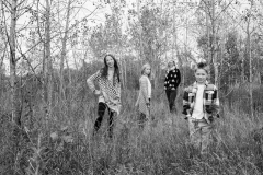 A black and white family portrait in a fall Michigan field