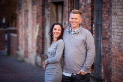 A husband and wife pose together in an urban Grand Rapids family session