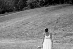 Striking black and white image of a mother in a white dress holding hands with her young child