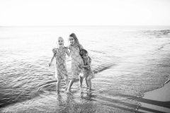 Siblings laugh while wading at a Lake Michigan beach