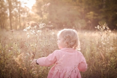 A setting sun backlights a girl running through a field