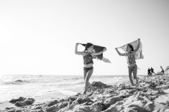 Girls hold towels and run down a Lake Michigan beach