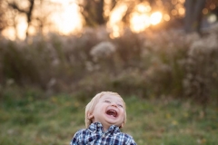 A young boy throws back his head and laughs at Johnson Park