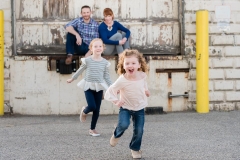 Lifestyle family portrait image of children laughing and running