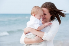 The blue waters of Lake Michigan provide a backdrop for this mom snuggling with her young son