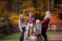 Siblings look at each other and laugh in a Grand Rapids family portrait