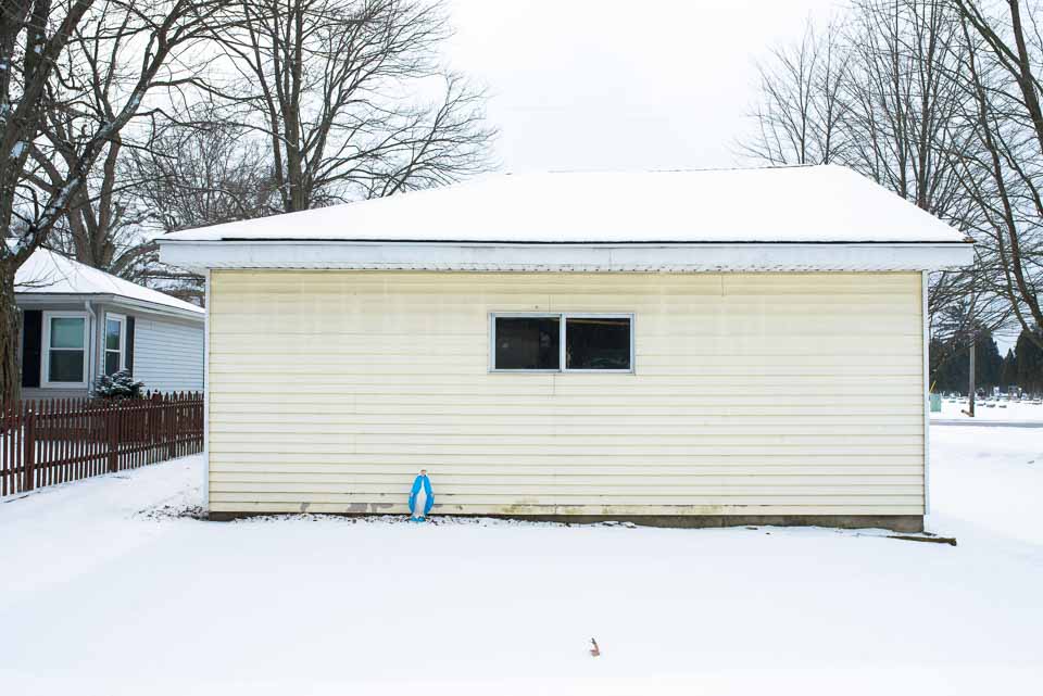 blue-shawled-madonna-behind-snowy-garage