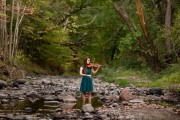 Senior picture of girl playing violin in a stream