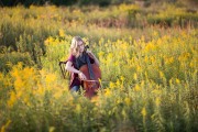 Senior portrait of girl playing violin in a Grand Rapids field