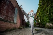 Senior photo of a senior girl performing a karate kick in urban Grand Rapids