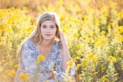 Yellow flowers surround a Grand Rapids senior girl in her senior portrait