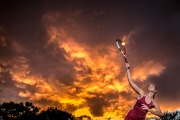 Dramatic sunset backdrop for Grand Rapids senior portraits of a leaping tennis player