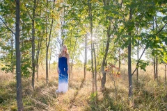 Beautiful girl in a dress poses for senior portraits near Grand Rapids