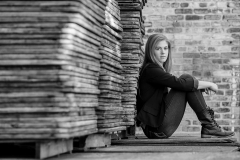 Grand Rapids senior poses against pallets in downtown Grand Rapids senior pictures