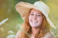 A sunhat complements a natural fall field setting for Grand Rapids senior portrait photography