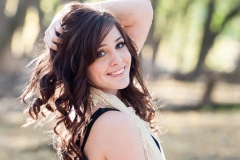 A senior girl poses in natural woods near Grand Rapids