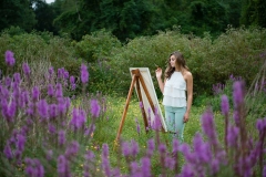 Senior photography of girl painting in a Grand Rapids flower field