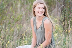 Beautiful senior girl laughs in a field of flowers for Grand Rapids senior portraits