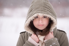 Girl holds a hood tight around her face in a Grand Rapids winter senior portrait