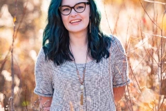 Sunlit grasses frame a Grand Rapids girl's senior portrait