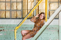 Young woman poses on stairs for Grand Rapids high school senior portraits