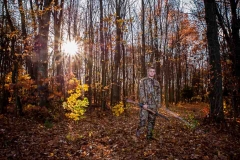 Senior portraits of a camouflaged boy hunter in a West Michigan forest