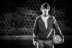 Grandville High School boy soccer athlete poses on the soccer field for male senior portraits