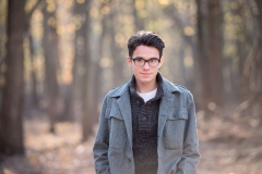 Fall high school male senior portraits of a boy in Michigan woods near Grand Rapids