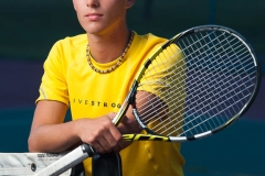 Tennis player poses for male senior pictures by a Grand Rapids senior portrait photographer