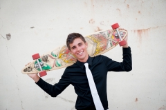 Grand Rapids senior boy poses with a longboard for male urban senior pictures