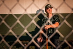 Baseball player poses for senior portraits by Grand Rapids senior portrait photographer